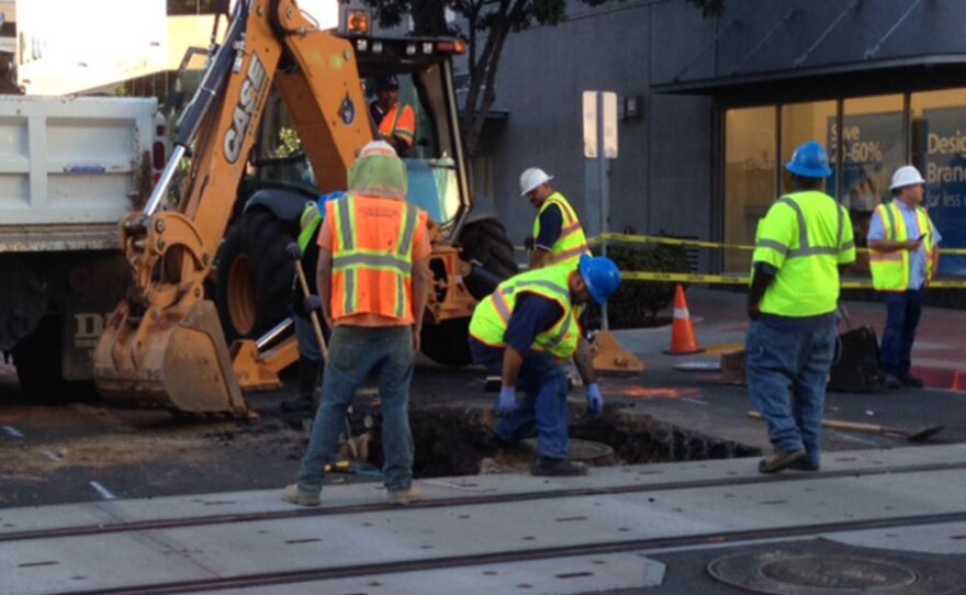 Crews work to repair a hole in the asphalt in downtown San Diego, Aug. 5, 2015.