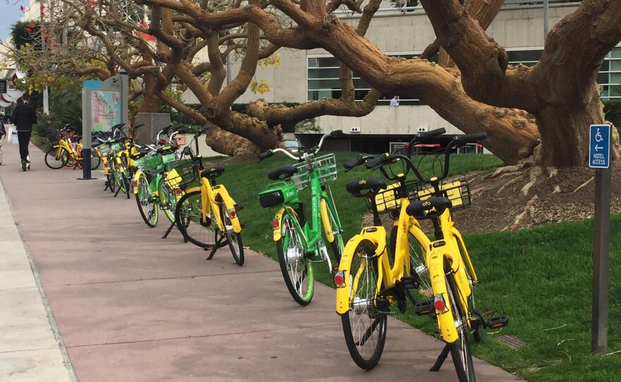 A row of dockless bike-sharing bicycles are parked on a sidewalk in downtown San Diego, March 23, 2018. 