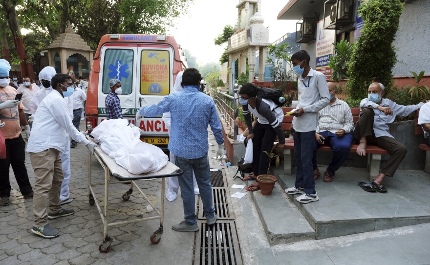 Relatives carried the shrouded body of a family member, who died of COVID-19, from an ambulance to a crematorium in New Delhi.