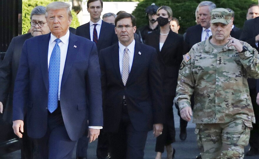 President Trump walking from the White House to St. John's Church on June 1. Gen. Mark Milley (far right), chairman of the Joint Chiefs of Staff, was among those walking behind the president. Milley says his presence was "a mistake" that he has learned from, but the incident has prompted discussions about how the military can maintain nonpartisanship within the Trump administration.