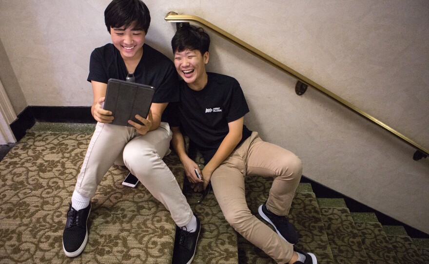Taking a break, Youngmo Koo (left) and Ryan Lee of South Korea pass the time with a video game.