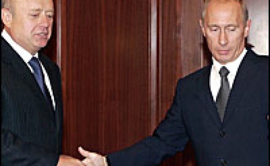 Russian President Vladimir Putin (right) welcomes Prime Minister Mikhail Fradkov during a meeting in Moscow on Wednesday. Putin accepted the Fradkov's resignation, saying that Russia needs to prepare for upcoming parliamentary and presidential elections.