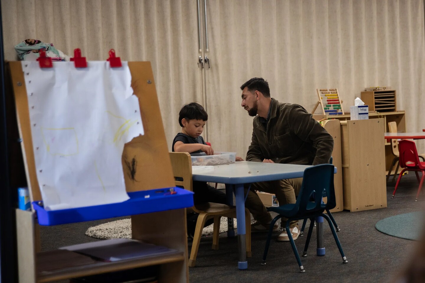 Behavioral Specialist Sebastian Lavenant works with a student during class at Mi Escuelita in San Diego on April 23, 2025. The preschool has eight teachers, two on-site therapists and a behavioral therapist on staff. While therapists mainly focus on the mental health of a student, behavioral therapists center on examining the actions and conduct of a student to see what may be triggering them or getting in the way of them interacting with others.
