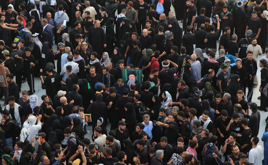 Crowds of pilgrims gather in the area between the two holy shrines in Karbala during Arbaeen, as one of them holds up a portrait of Iran's Supreme Leader Ali Khamenei.