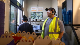 Ebert Velasquez Ramos (right) works at the drive-through at a McDonald's in Morningside, Md. He doesn't have a car so he sometimes turns to Escalate, a startup that provides Uber vouchers for workers who need last-minute rides among other support.