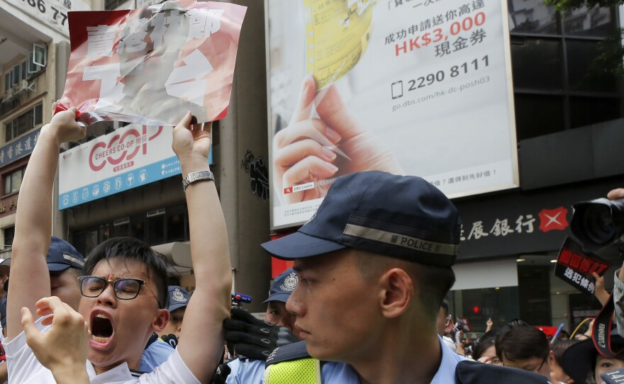 A protester shouts next to policemen during a rally against the proposed amendments to extradition law in Hong Kong.