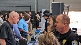 Police officers, Customs and Border Protection agents and other agency representatives talk with veteran job-seekers at a San Diego military and veterans job fair Sept. 13, 2025.