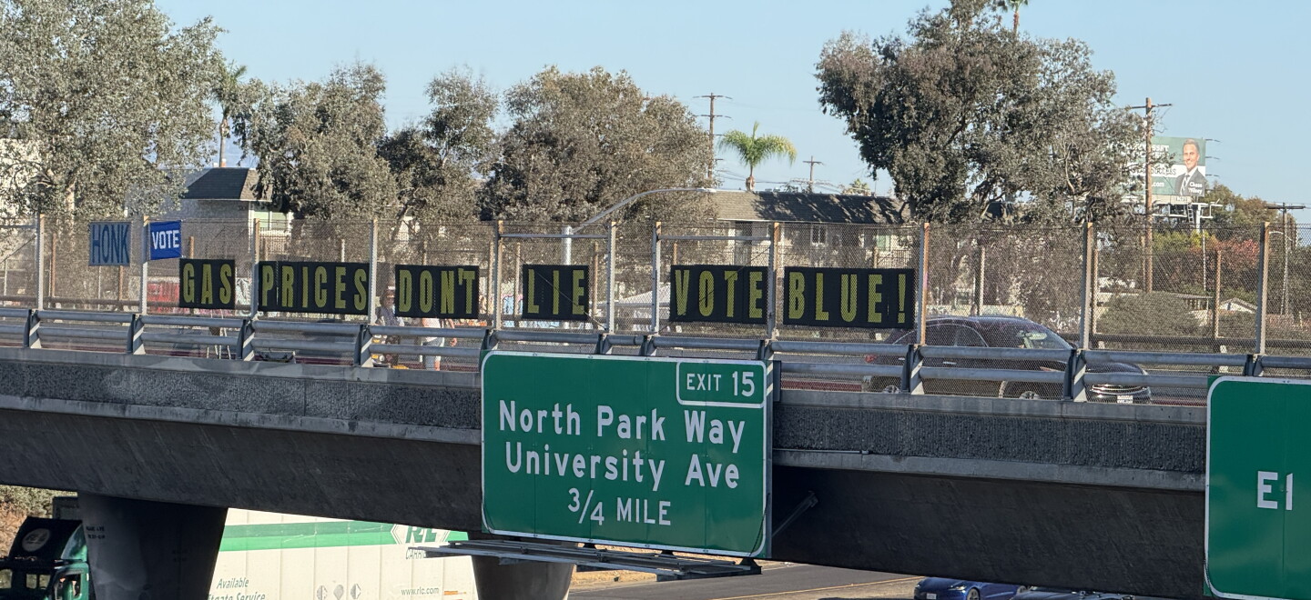 Letters spelling out the phrase, "Gas prices don't lie. Vote blue," are displayed on the Meade Avenue bridge over Interstate 805 on Oct. 8, 2026.