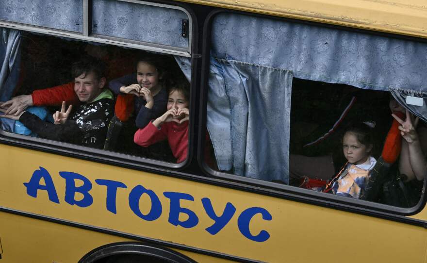 Young Ukrainian evacuees react in a bus while they drive on a road east of Kharkiv, in northeastern Ukraine, on May 30, during the Russian invasion of Ukraine.