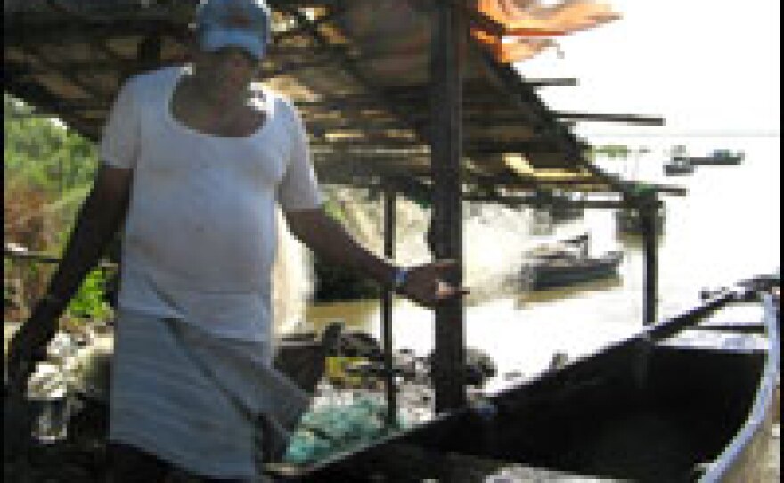 Fisherman R.B. Boya standing next to his boat.