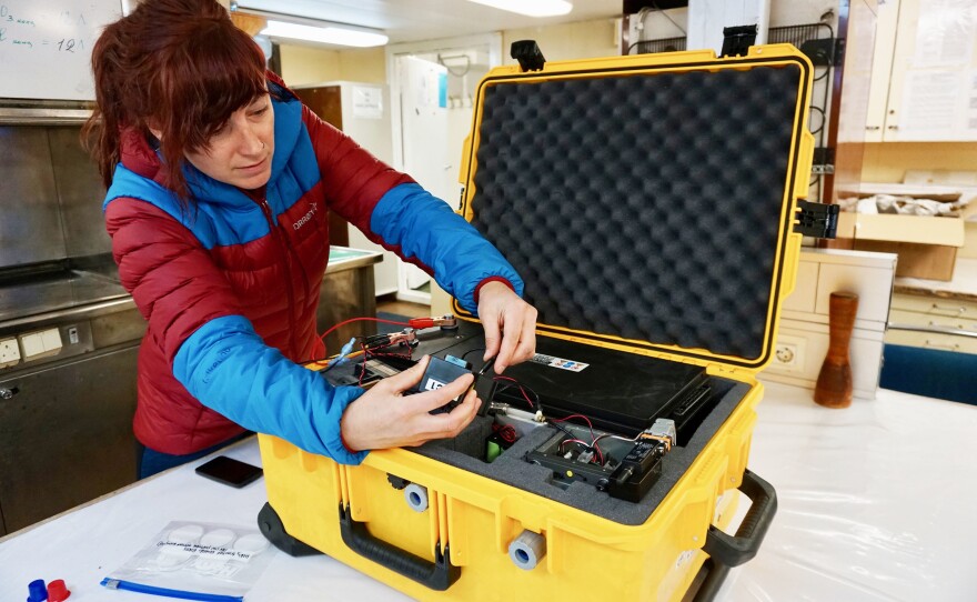 Scientist Jessie Creamean and her portable aerosol sampler in the lab on the research vessel Akademik Fedorov.