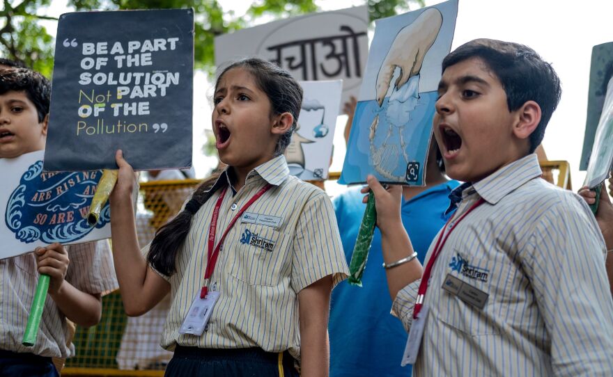Children shout slogans as they participate in a climate strike in New Delhi.