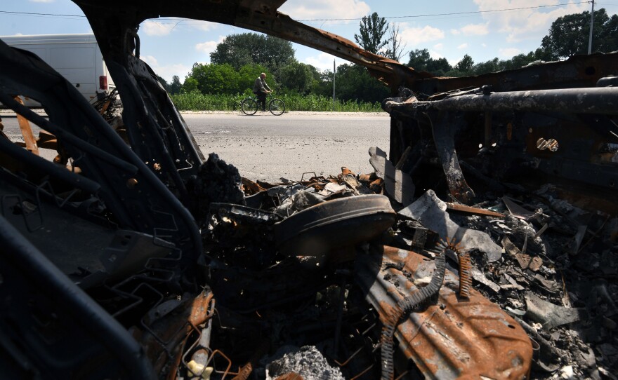 The charred remains of Oleksandr Breus' vehicle are parked on the side of the road in Nova Basan.