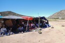 A group of people wait to be processed after crossing the border between Mexico and the United States as they seek asylum in April 2024, near Jacumba, Calif.