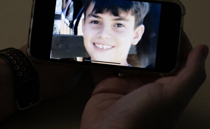 Ido holds a photo of his nephew, Erez, who is 11 years old, on his phone in his hand. Erez is feared to be have been abducted and there is a video circulating believed to show the moment a Hamas fighter grabbed him.