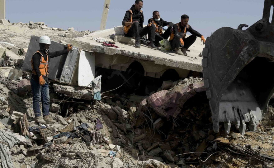 Gaza civil defense crew members search beneath the rubble of the Abu Naser family home, which was targeted by Israel's military in October 2024, in one of the deadliest Israeli strikes of the Gaza war.