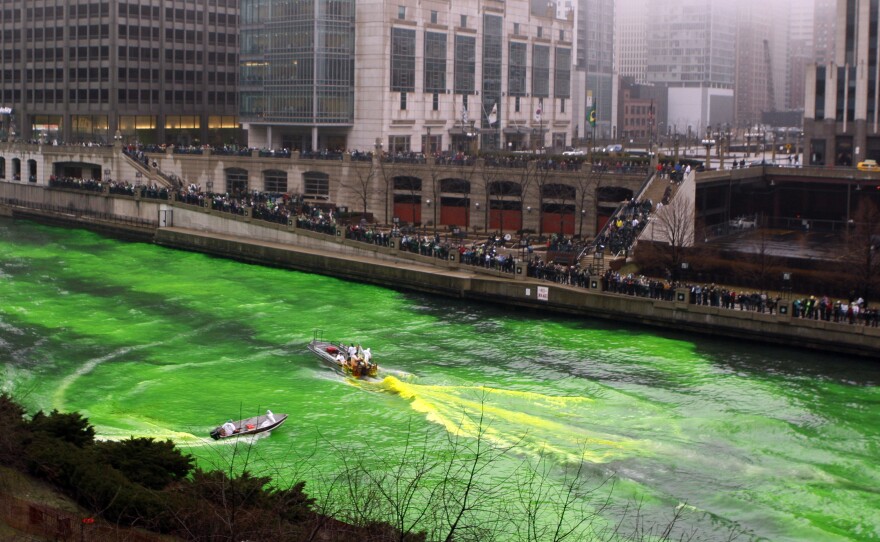 People watch as the Chicago River is dyed green (using an orange powder) on March 13, 2010, as part of the city's celebration of St. Patrick's Day.