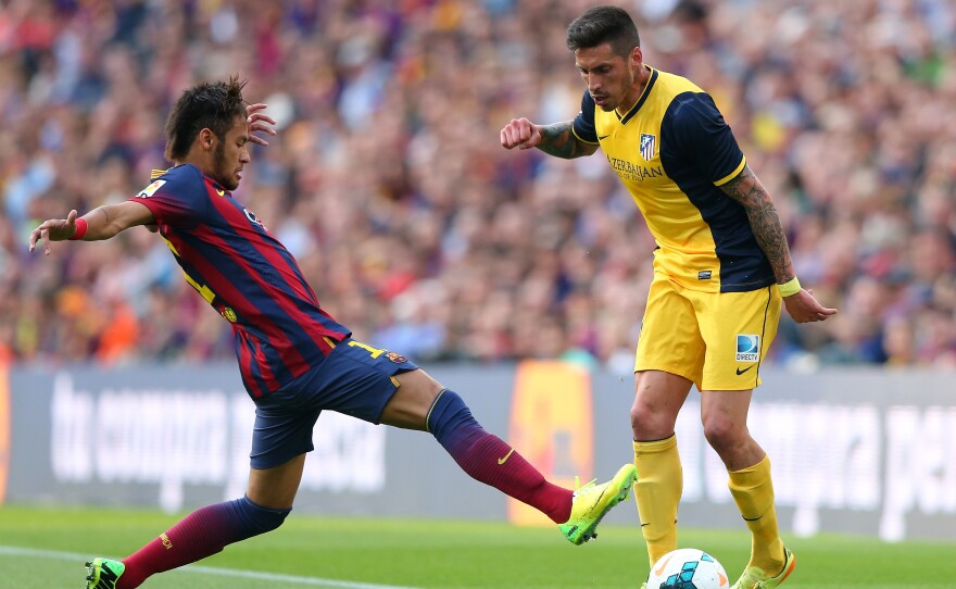 Allegations surrounding the signing of Neymar da Silva Santos Júnior of FC Barcelona (shown here, left, tackling Jose Sosa of Club Atletico de Madrid on May 17 in Barcelona) are at the heart of tax fraud charges against the storied soccer club.