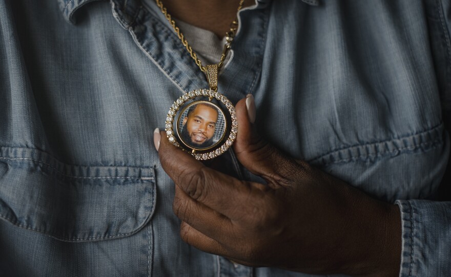 Tanya Warden, 55, holds a necklace with a photo of her son, Tyron Alexander, at her office in Philadelphia on Tuesday, March 26 2024.