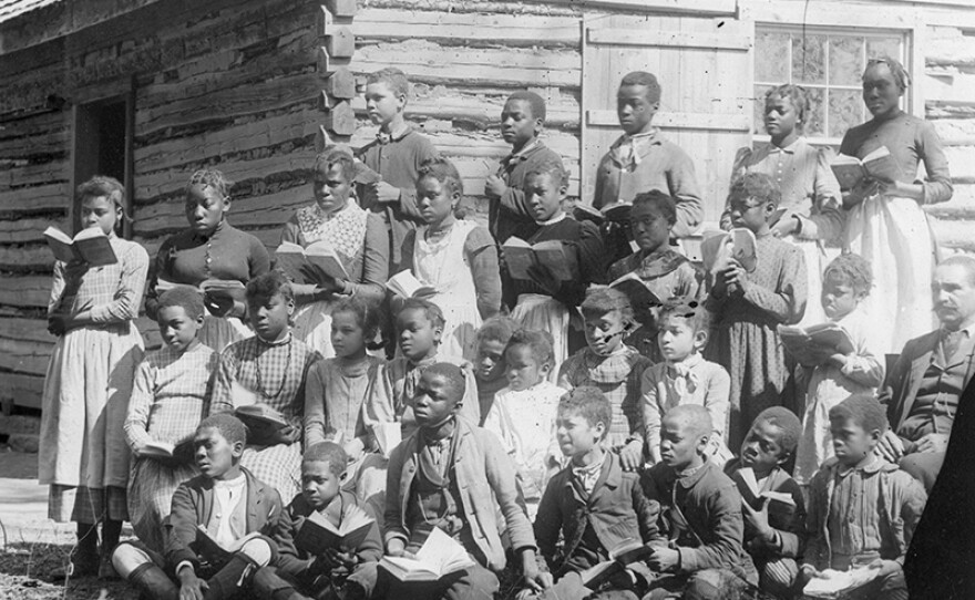 Group of freed slaves with books.