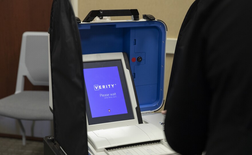 Lisa Bosch, of Wright Township, waits for the ballot reading machine to turn on during a poll worker training at the Ottawa County Clerk building.