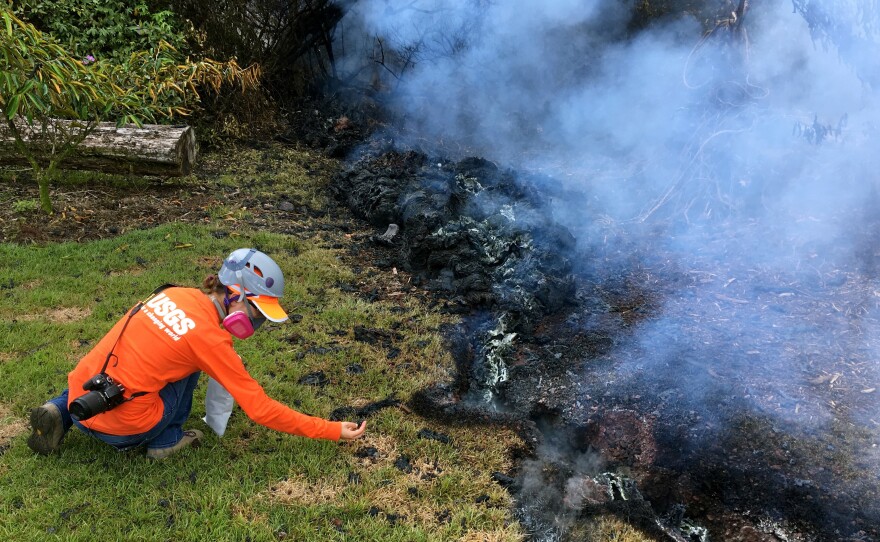 A Hawaiian Volcano Observatory geologist collects samples of spatter for laboratory analysis on Sunday in the Leilani Estates subdivision near Pahoa.
