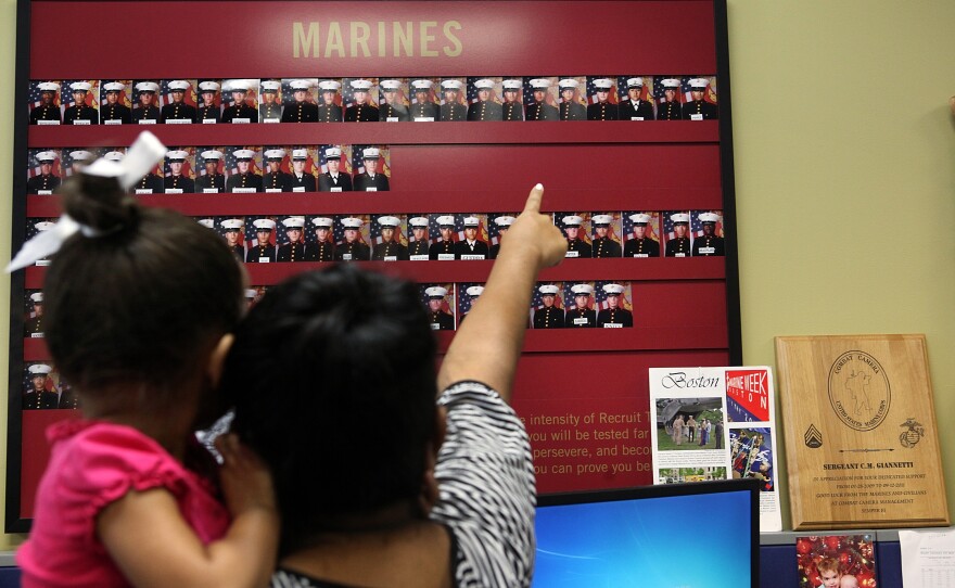 Victor's sister shows her daughter what he will wear when he is a Marine.