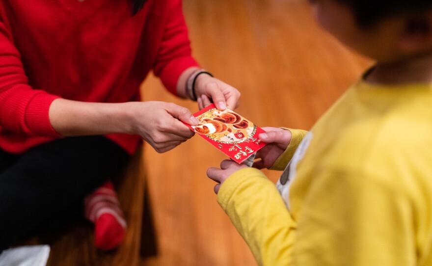 Thao Nguyen gives her nephew, Hayle, a red envelope in celebration of the Lunar New year on Jan. 26, 2020.