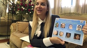 In this Oct. 15, 2018 photo, Darling Perez shows a copy of a Nicaraguan government wanted poster in which she is listed, during an interview in Miami. Perez, a pediatrician, worked at a public hospital in Nicaragua and was told not to take care of patients who were hurt during protests. She refused and began helping wounded students at private clinics. Perez, her husband and 12-month-old baby, all of whom arrived in the U.S. on tourist visas, are now seeking asylum in the U.S. 