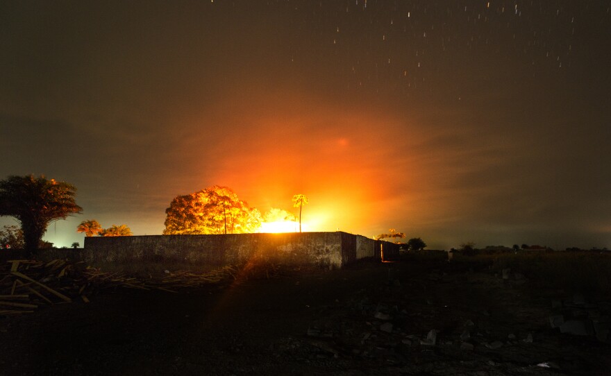 The glow from a crematorium fire lights up the night sky where bodies of people who died from Ebola are cremated on in Monrovia, Liberia.