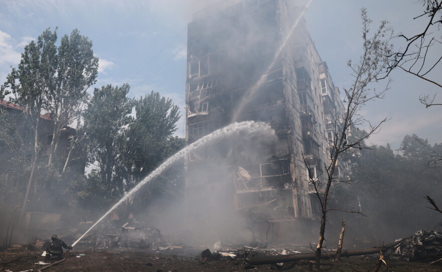 Rescue workers try to put out a fire of a residential building burning after a Russian air guided bomb strike in Zaporizhzhia, Ukraine, Tuesday, July 21, 2026.