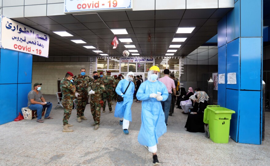 People wait for COVID-19 tests at a hospital in Baghdad on June 4.