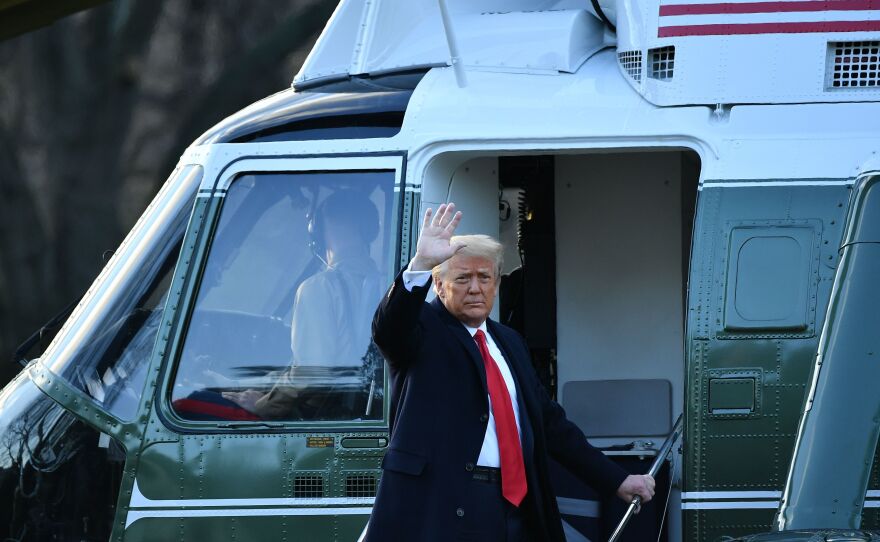 Outgoing President Trump waves as he boards Marine One after leaving the White House.