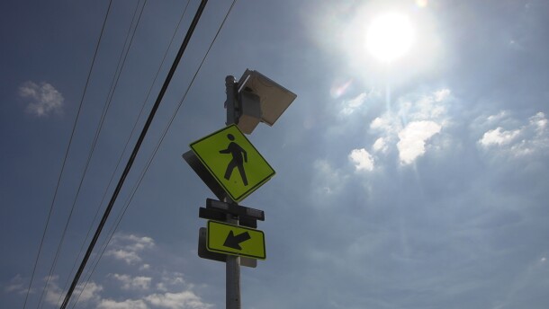 The sun glares over a crosswalk sign in front of Village View County Park in Fallbrook, Sept. 30, 2025.