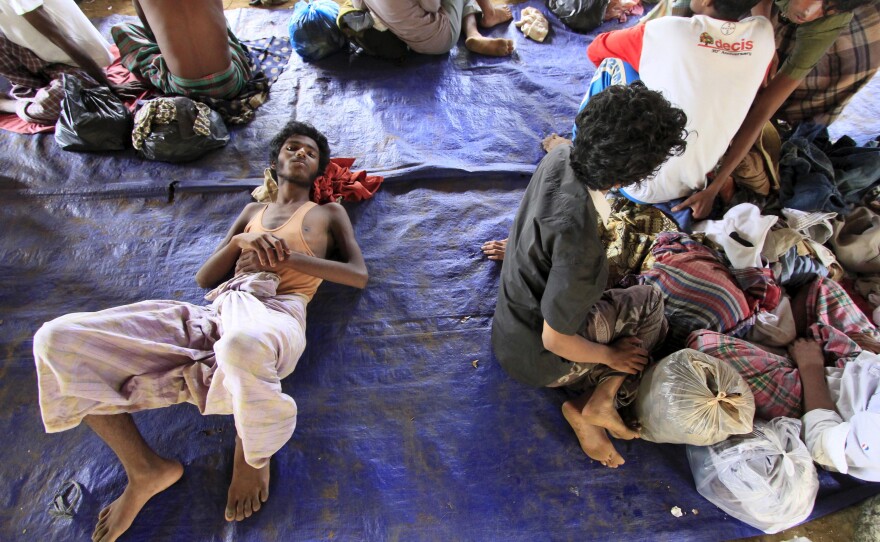 Rohingya refugees sit on a plastic sheet at Matang Raya village, Baktya district in Aceh Utara, Aceh province, Indonesia, on Sunday. Nearly 600 migrants thought to be Rohingya refugees from Myanmar were rescued from two wooden boats stranded off the coast of Indonesia's northern Aceh province, authorities said.