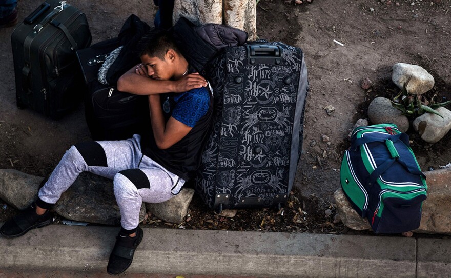 An asylum seeker rests outside El Chaparral port of entry while he waits for his turn to present himself to U.S. border authorities to request asylum, in Tijuana, Mexico, last month. A federal appeals court has granted the Trump administration's request to temporarily allow the government to continue to return asylum seekers to Mexico while it appeals a ruling that blocked the policy.