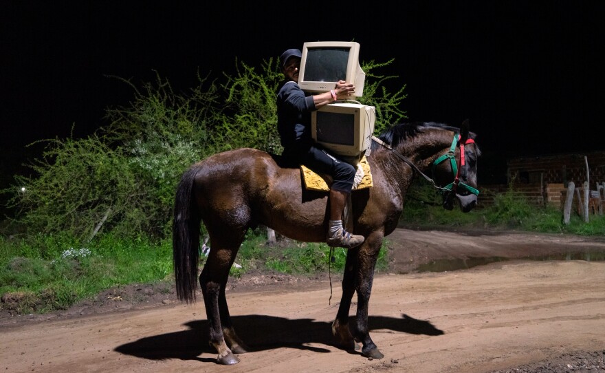 A man transports computer monitors on horseback in Corrientes, Argentina.