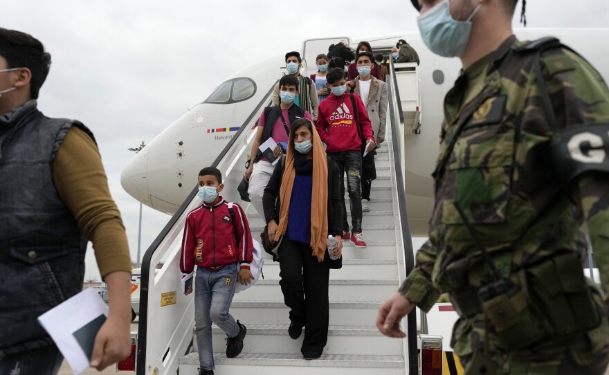 Afghan music students, teachers and their families disembark from their flight to Lisbon on Dec. 13. The group of more than 270 evacuees had been staying in Doha, awaiting resettlement in Portugal.