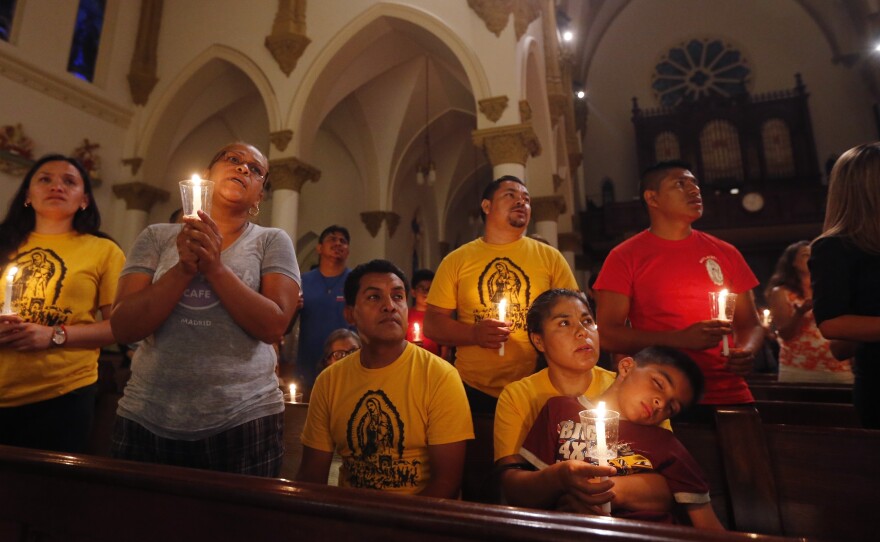 Worshipers participate in a "United To Heal Prayer Vigil" at Cathedral Guadalupe in Dallas on Friday, in honor of the police officers who were slain on Thursday.