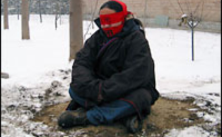 Artist Kuang Laowu performs a work of art entitled "Shut" during an exhibit at the Songzhuang artists' colony. The Chinese character for "shut" is written on the red cloth wrapped around his eyes, ears and mouth.