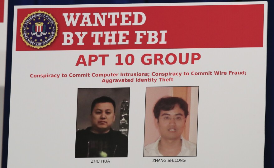 A Justice Department poster shows two Chinese citizens suspected of carrying out an extensive hacking campaign directed at dozens of U.S. tech companies. U.S. law enforcement says such cases are on the rise as China seeks to become a world leader in advanced technologies by 2025.