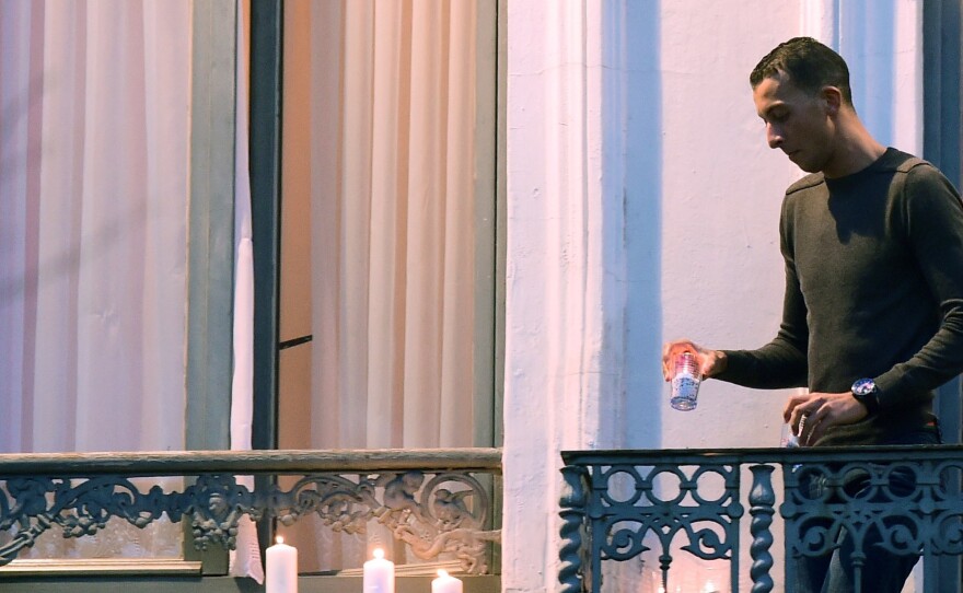 Mohamed Abdeslam places candles on a window ledge of his family's apartment Nov. 18 during a candlelight vigil in Brussels' Molenbeek district town square. Two of his brothers were among the attackers in Paris on Nov. 13.