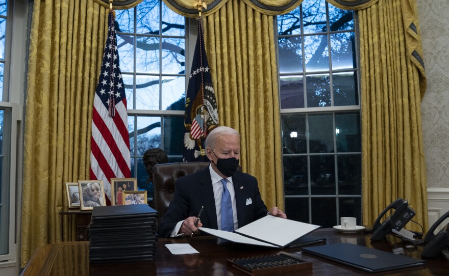 In this Jan. 20, 2021, file photo President Joe Biden signs a series of executive orders in the Oval Office of the White House in Washington.