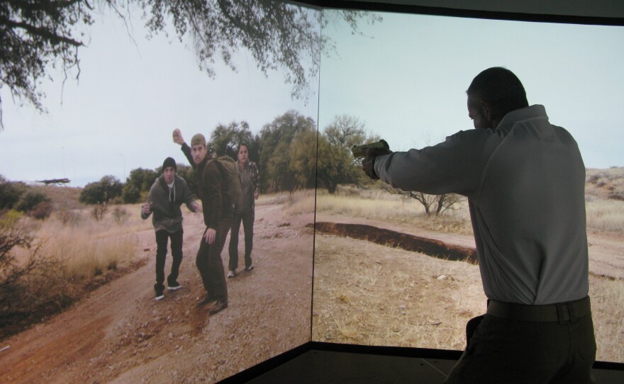 In order to reduce shootings, all Border Patrol agents are now required to train in a simulated environment complete with immigrants threatening rocks. Agent Aaron Sims unholsters his taser  at the CBP National Training Center in Harpers Ferry, West Virginia.