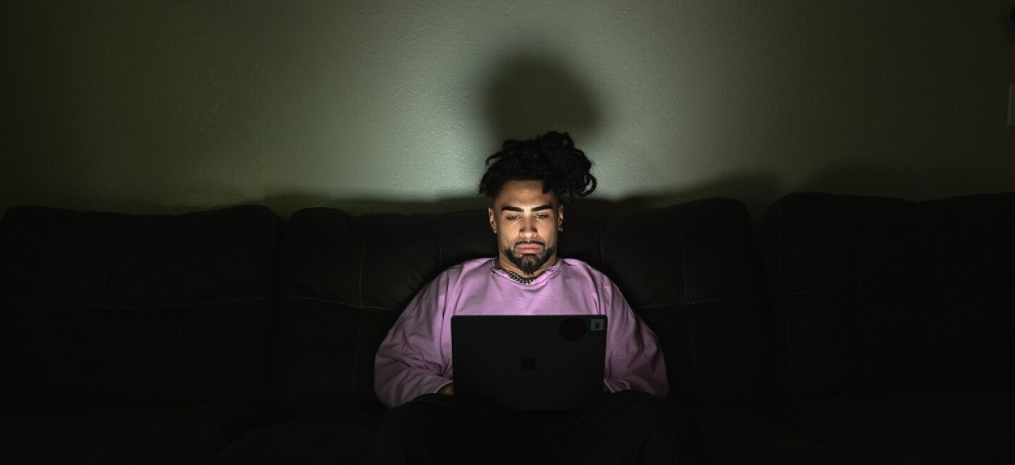 Jodeah Wilson, 22, on his laptop at his off-campus apartment near Sacramento State University on Oct. 17, 2025. Wilson, a former Sac State student, left school this semester after being unable to afford tuition.