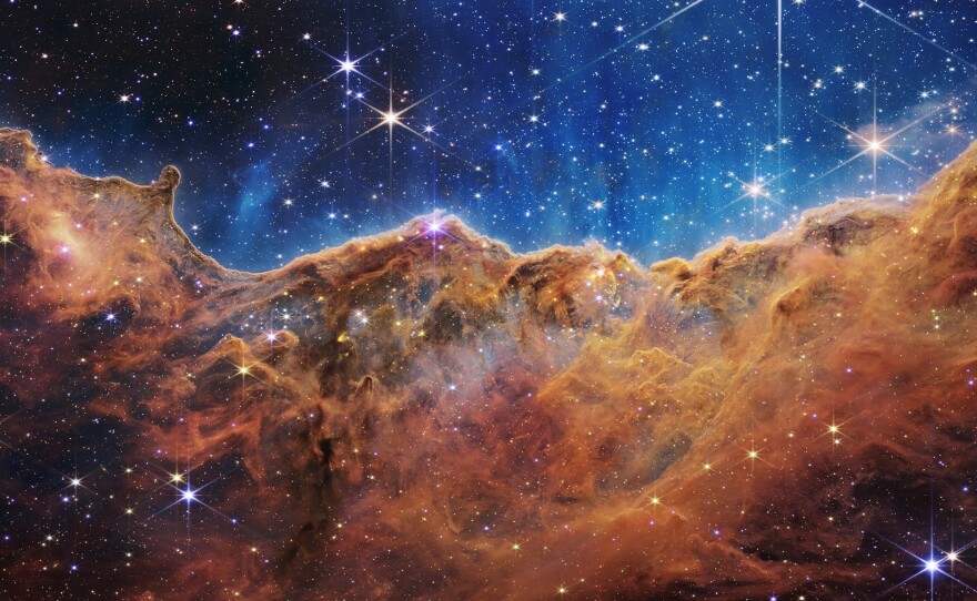 What looks much like craggy mountains on a moonlit evening is actually the edge of a nearby, young, star-forming region NGC 3324 in the Carina Nebula. Captured in infrared light by the Near-Infrared Camera (NIRCam) on NASA's James Webb Space Telescope, this image reveals previously obscured areas of star birth.