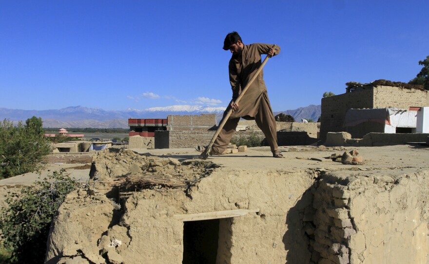 A man clears rubble from the roof of his house in the Behsud district of Jalalabad province, Afghanistan, on Tuesday.