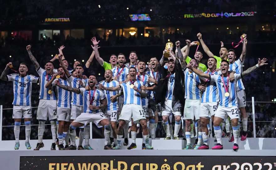 Argentina's Lionel Messi holds up the winner's trophy after the team won the 2022 World Cup final against France on Sunday, Dec. 18, at the Lusail Stadium in Lusail, Qatar.