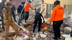 In this photo released by the Indonesian National Search and Rescue Agency (BASARNAS), rescuers attempt to clear debris at building damaged by an earthquake in Maumere, East Nusa Tenggara Province, Indonesia, Saturday, Aug. 15, 2026.