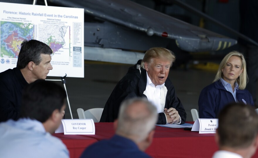 President Trump speaks while attending a briefing at Marine Corps Air Station Cherry Point in Havelock, N.C, on Wednesday, during a trip to visit areas impacted by Hurricane Florence. North Carolina Gov. Roy Cooper (let) and Homeland Security Secretary Kirstjen Nielsen (right) also attended the briefing.